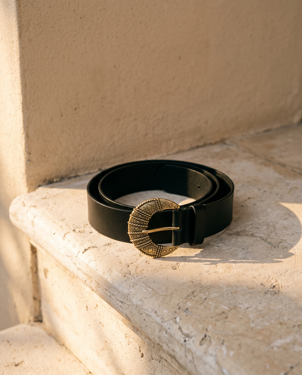 Ceinture LAURA noire à boucle western enroulée sur une marche en pierre — A by André