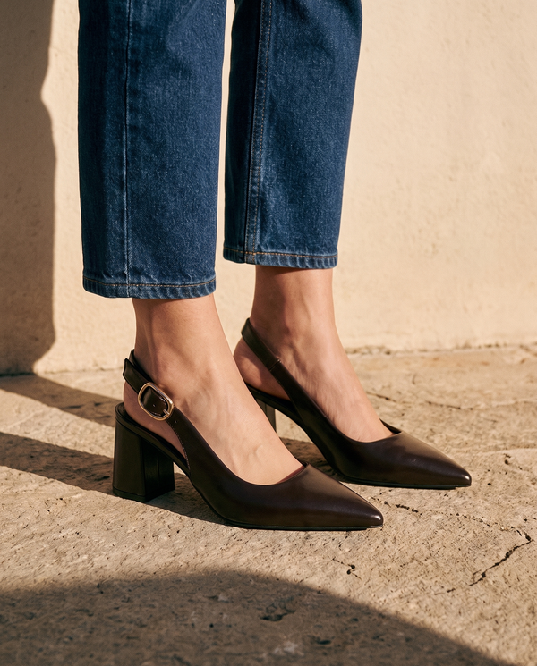Gros plan sur les chevilles portant les slingbacks THAÏS marron — A by André