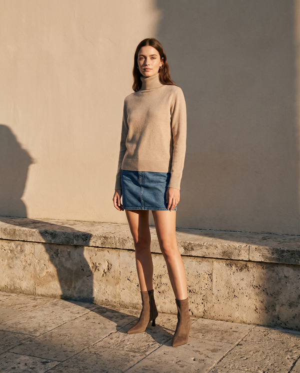 Boots VANINA taupe portées avec une jupe en jean sur une terrasse en pierre — A by André