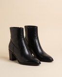 Boots AELLE noires debout sur fond beige