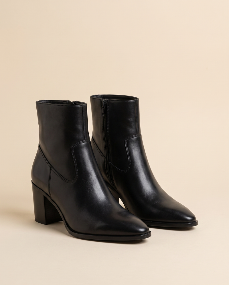 Boots AELLE noires debout sur fond beige