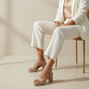 André Briseida Sable beige suede platform block heel sandals with ankle strap and buckle.