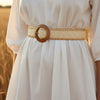 André Oasia beige woven paper belt with a round wooden buckle, perfect for summer outfits.