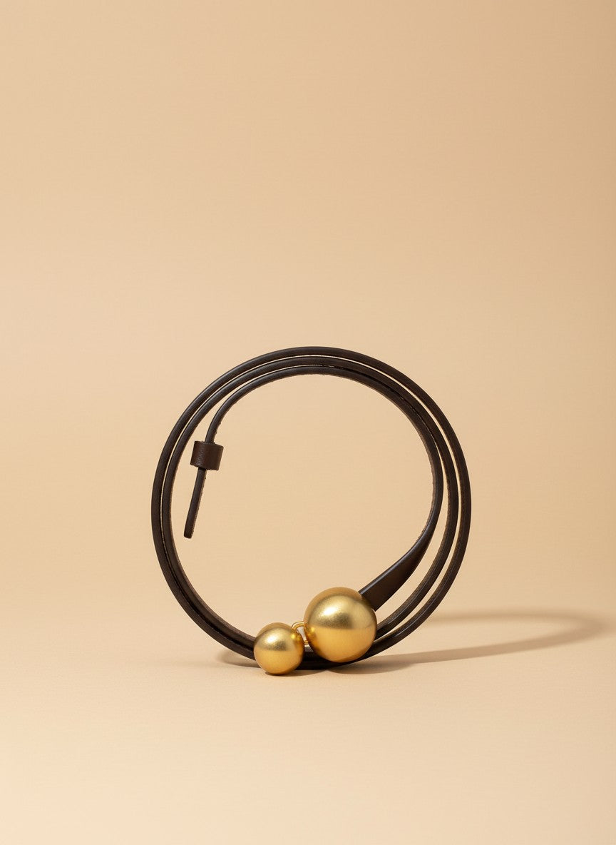 André brown leather belt with double gold ball buckle, ideal for cinching waists on jeans or blazers.