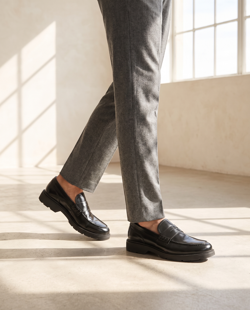 Mocassin ARCHIBALD noir porté, pantalon flanelle gris, sol béton clair