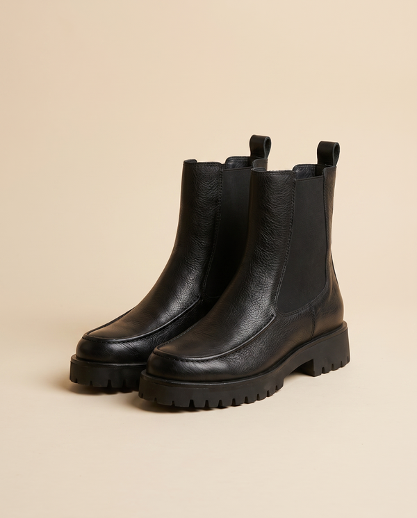 Boots AZERTY noires debout sur fond beige