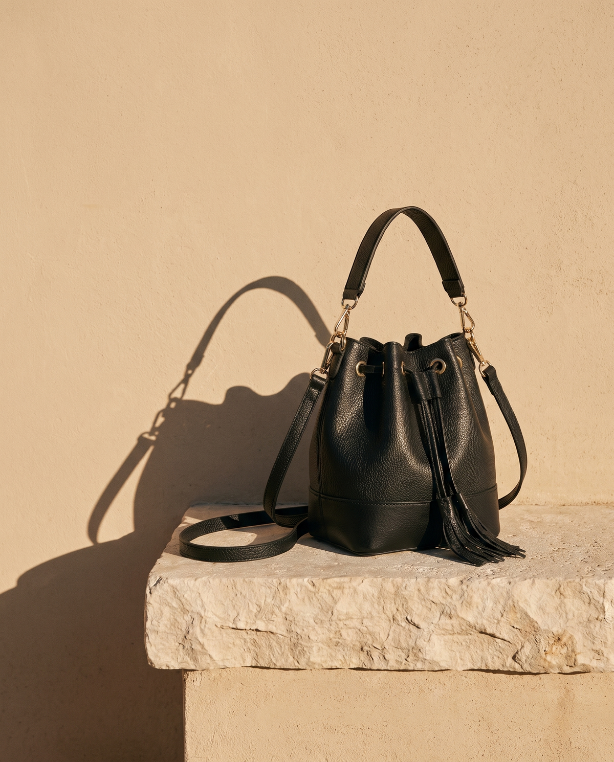 Sac BÉRÉNICE noir Maison André sur une marche en pierre