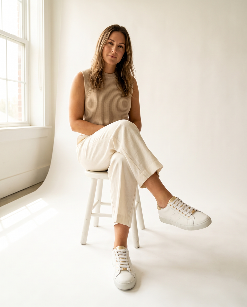 Basket BERKELEY blanche portée, femme assise sur un tabouret blanc en studio