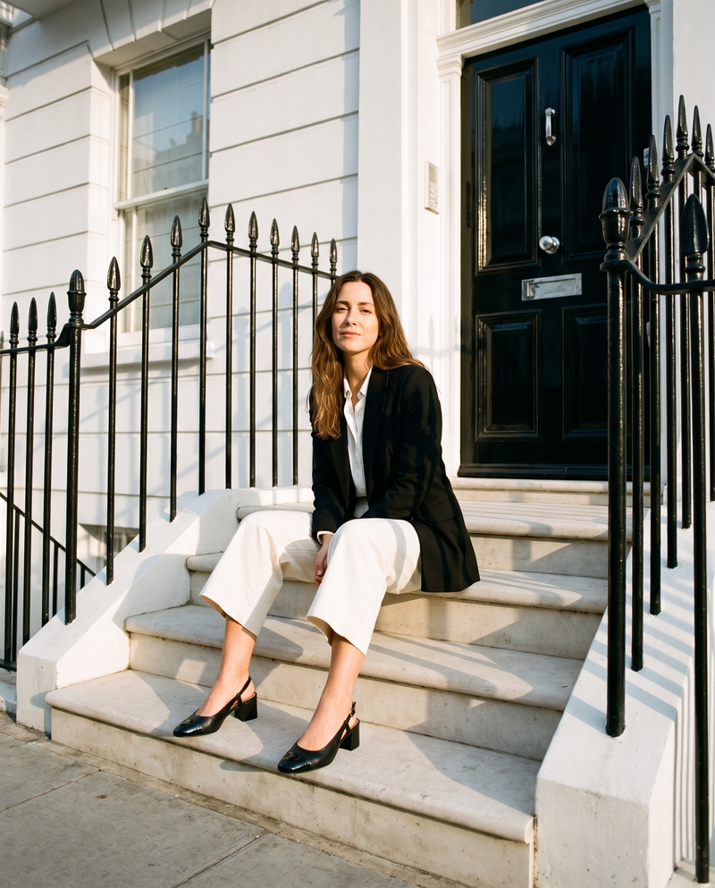 Slingback BRUNIE noire portée, femme assise sur le perron d'une maison londonienne