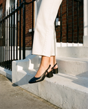 Slingback BRUNIE noire portée, gros plan, un pied posé sur la marche d'une maison londonienne