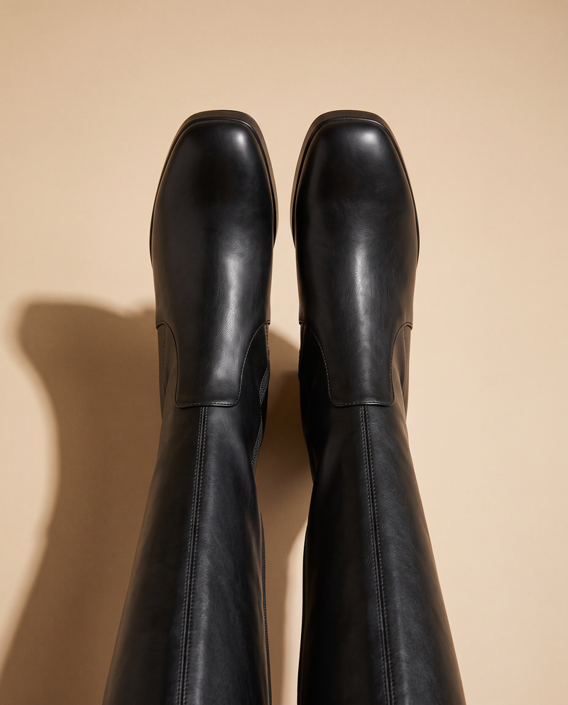 Paire de bottes CALIA noires vue du dessus sur fond beige — André
