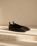 Ballerine Caliopa noir posée sur une marche en pierre