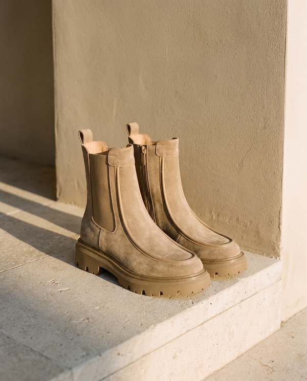 Paire de boots CASSIE taupe posée sur une marche en pierre — A by André
