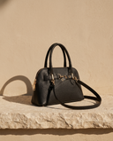 Sac CELIA noir Maison André posé sur une marche en pierre