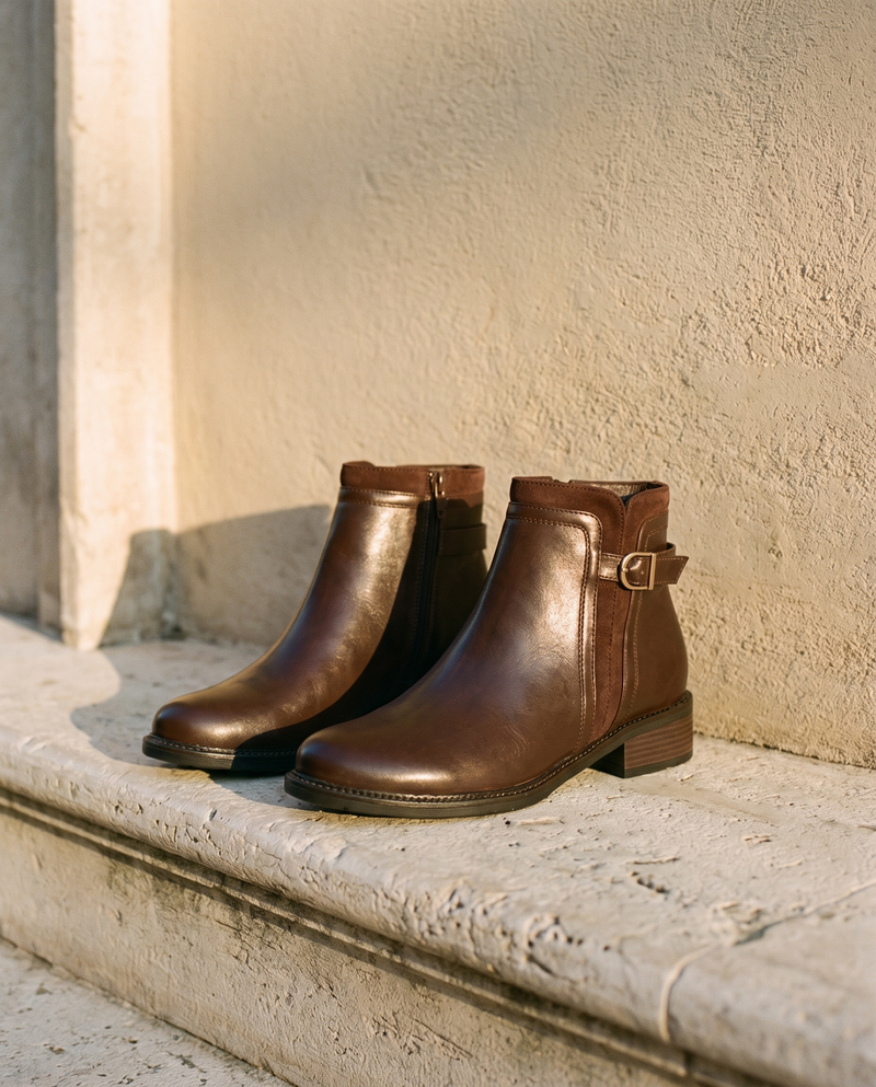 Paire de boots SAMIRA marron posée sur une marche en pierre — A by André