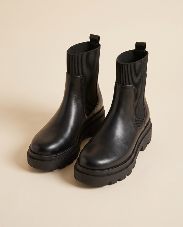 Boots DANIA noires debout sur fond beige