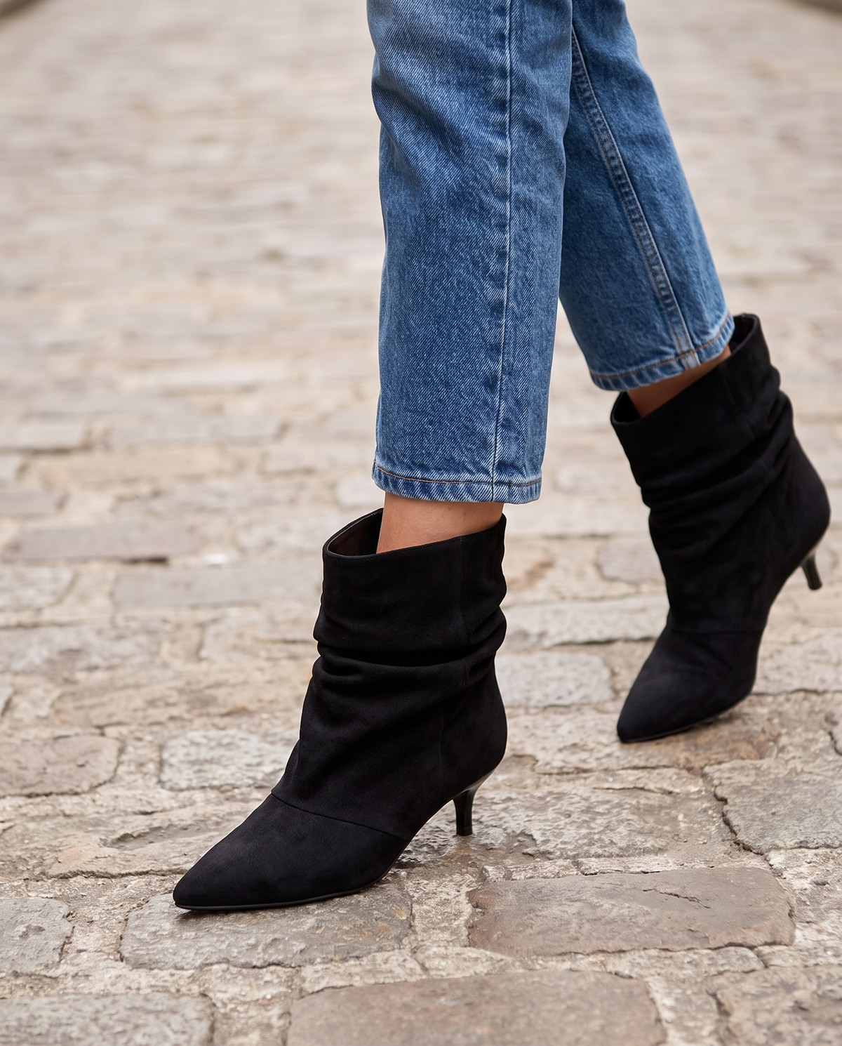 Bottine DELIA noir portée, gros plan jambes sur pavé