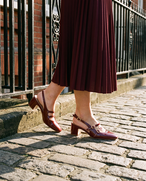 Slingback DEOTILLE bordeaux portée, gros plan, sur les pavés d'une rue londonienne