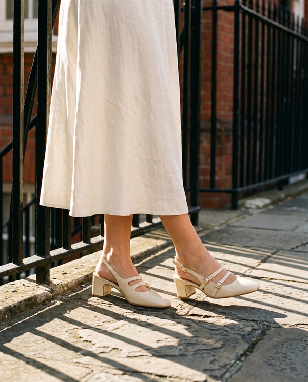 Slingback DEOTILLE écrue portée, gros plan, sur les pavés d'une rue londonienne