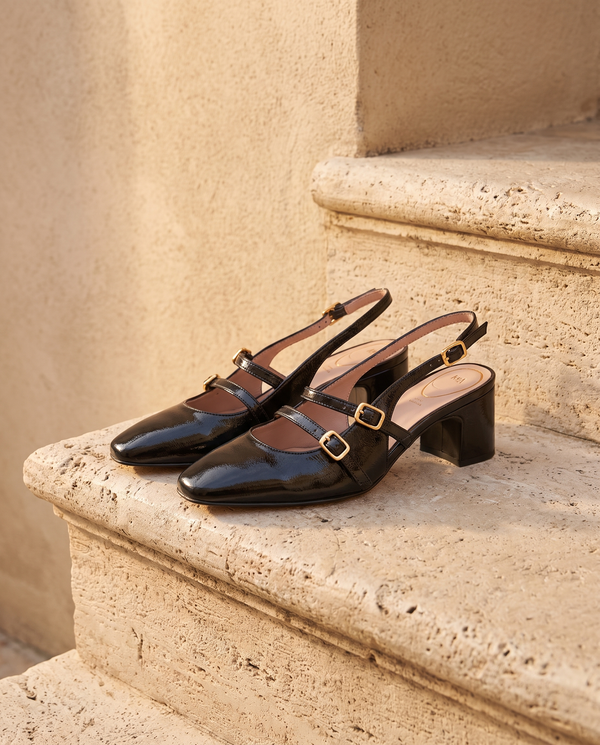 Slingback DEOTILLE noire posée sur une marche en pierre, mur enduit beige