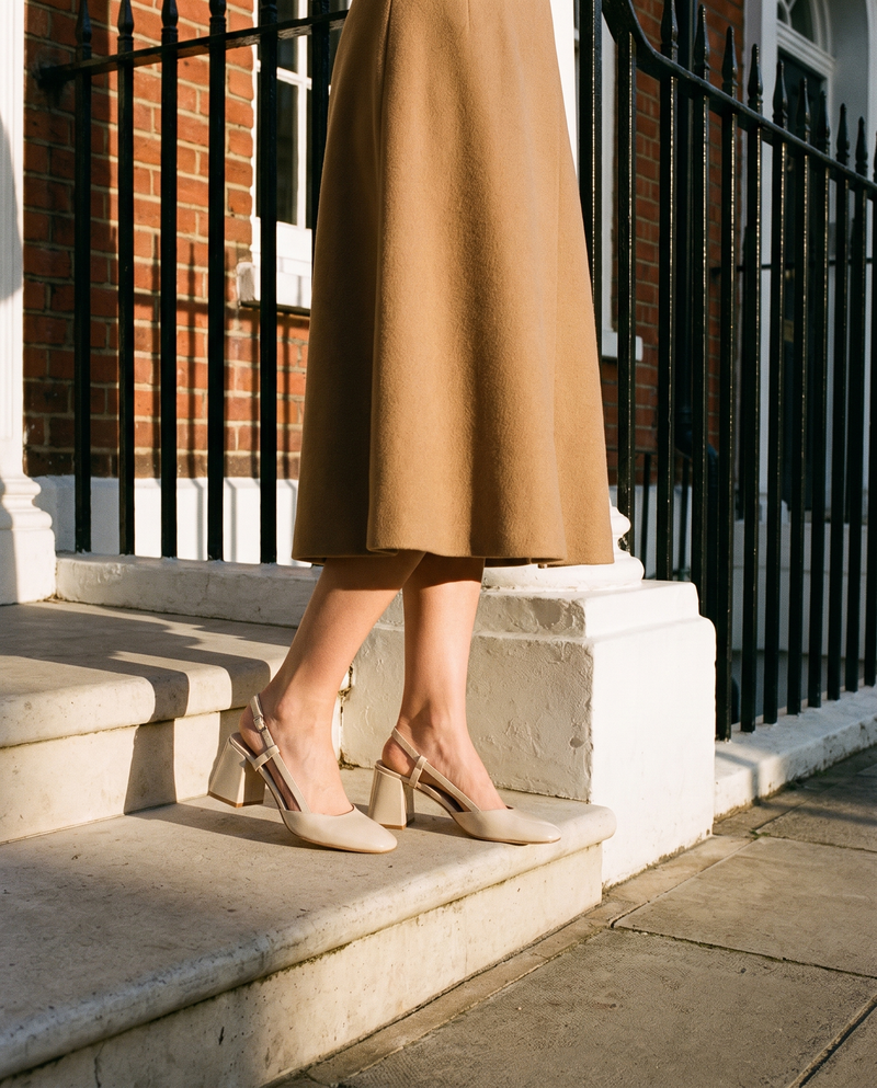 Slingback DONNA beige portée, gros plan, un pied posé sur la marche d'une maison londonienne