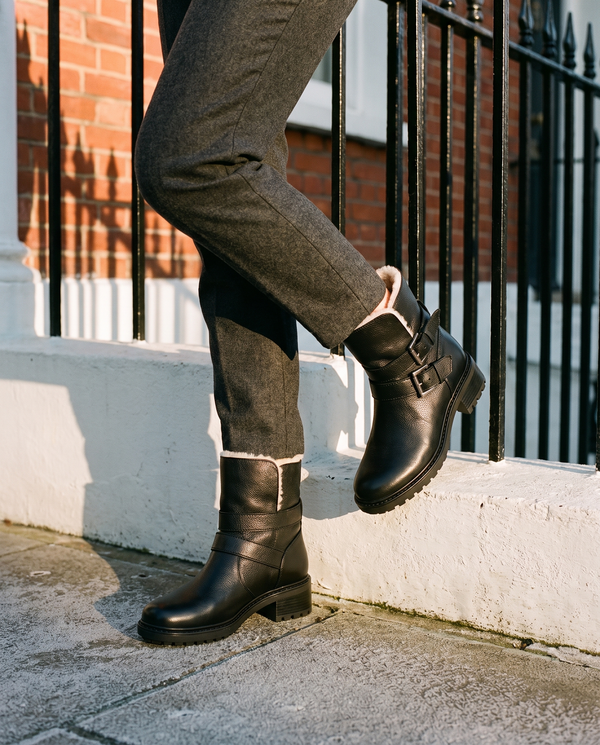 Boots fourrées DOUILLETTE noires portées, gros plan dans une rue londonienne