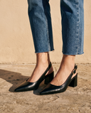 Gros plan sur les chevilles portant les slingbacks THAÏS noirs — A by André
