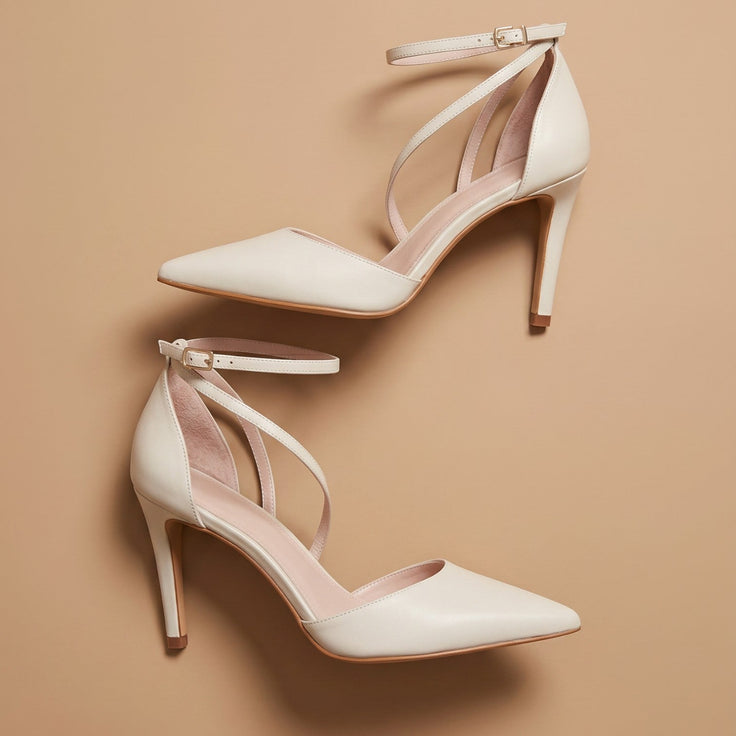 André escarpins en cuir beige à brides croisées et talon fin de 8,5 cm. Bout pointu et fermeture à la cheville.