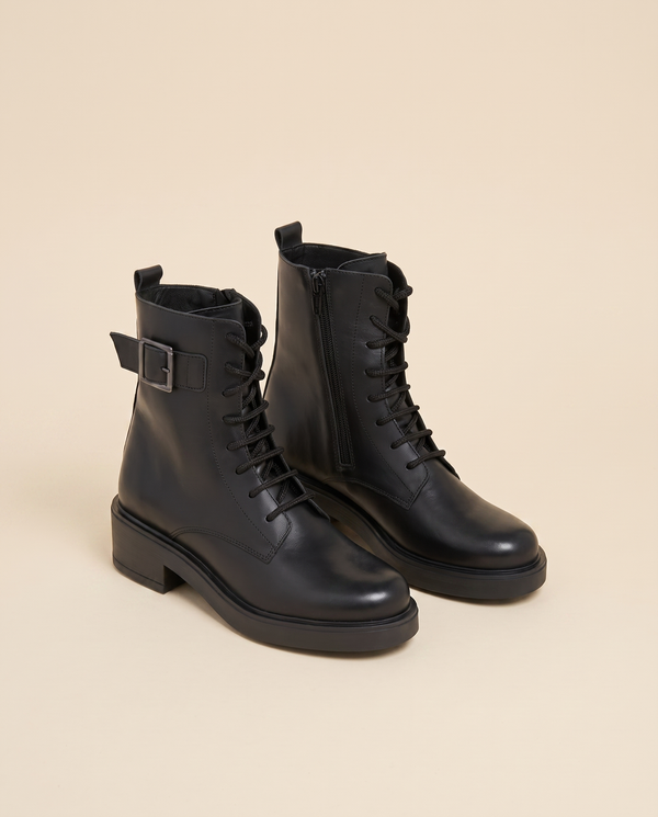 Boots EURIELLE noires debout sur fond beige