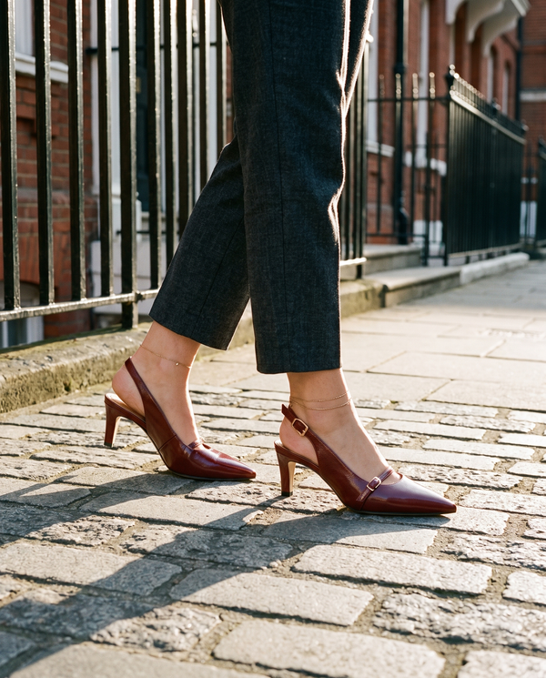 Slingback FIDJI bordeaux portée, gros plan, sur les pavés d'une rue londonienne