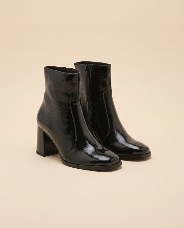 Boots FLORENCE noires debout sur fond beige