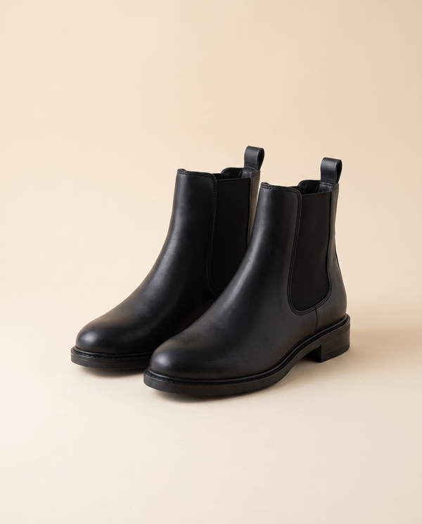 Boots GNOCCHI noires debout sur fond beige