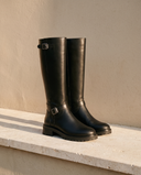 Paire de bottes HERENA noires posée sur une marche en pierre — André
