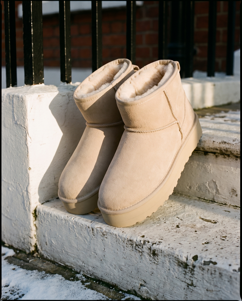 Boots fourrées ICY beige posées sur le perron d'une maison londonienne