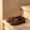 Derby ILONA camel posée sur une marche en pierre, mur enduit beige