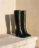 Paire de bottes IRIZIA noires posée sur une marche en pierre — André