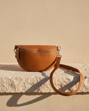 Sac banane ISLA cognac Maison André posé sur une marche en pierre