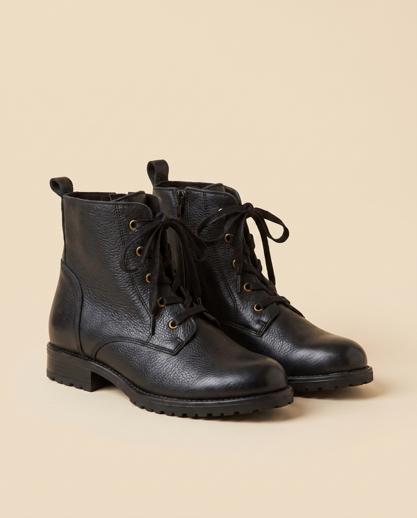 Boots IVA noires debout sur fond beige