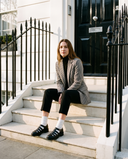 Derby IZZIE noir porté, femme assise sur le perron d'une maison londonienne