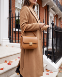 Sac JUNO cognac Maison André porté à l'avant-bras, sur le perron d'une maison londonienne en automne