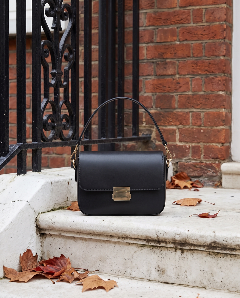 Sac JUNO noir Maison André posé sur le perron d'une maison londonienne, feuilles d'automne