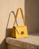Sac LEIA jaune doré Maison André sur une marche en pierre
