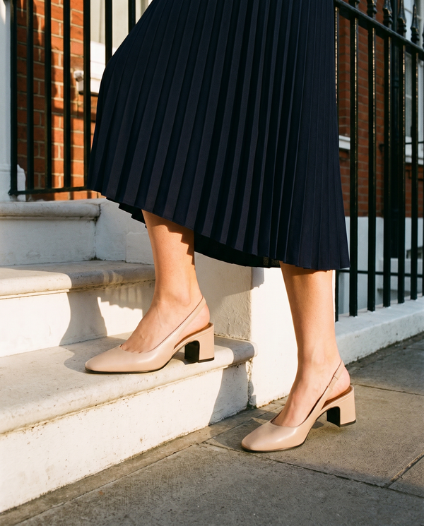 Slingback LIVIA beige portée, gros plan, un pied posé sur la marche d'une maison londonienne