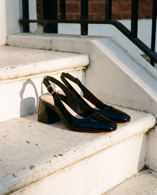 Slingback LOUISE noire posée sur le perron d'une maison londonienne