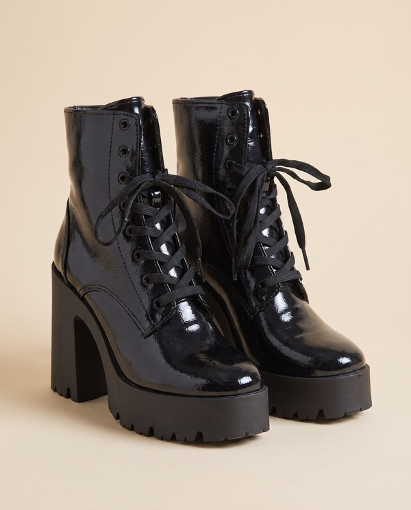 Boots MAYA noires debout sur fond beige
