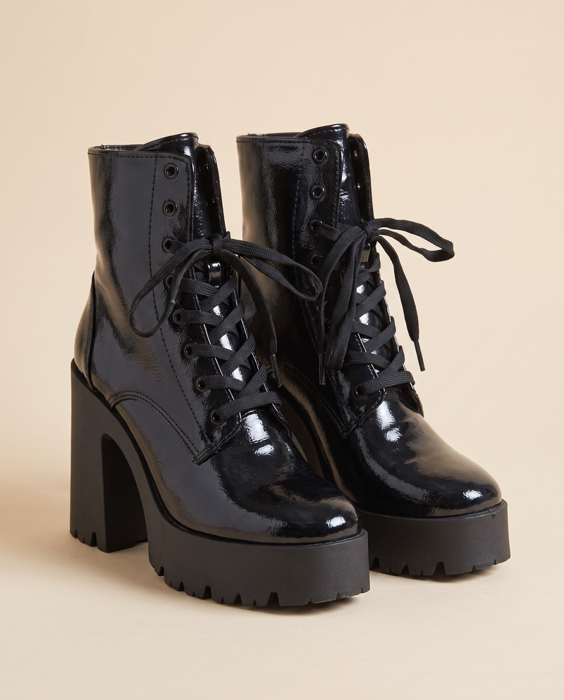 Boots MAYA noires debout sur fond beige