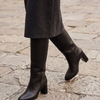 Botte NORAH noir portée, gros plan jambes sur pavé