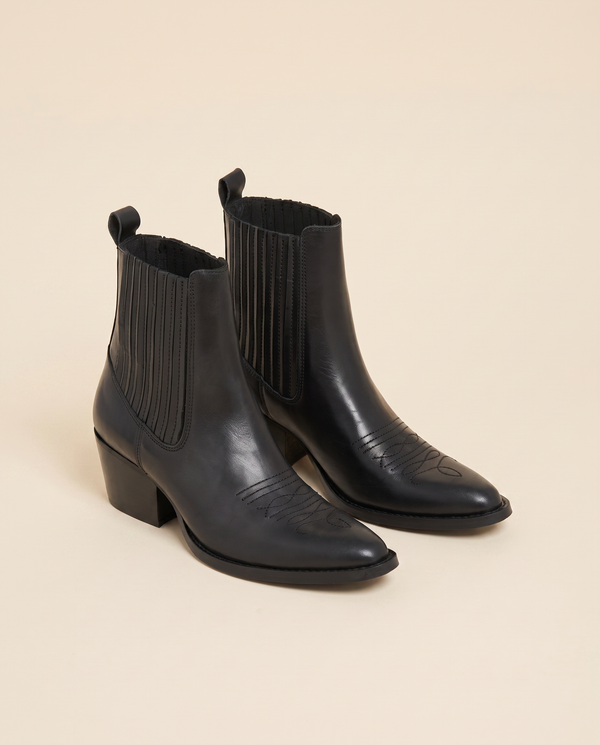 Boots ODELIA noir debout sur fond beige