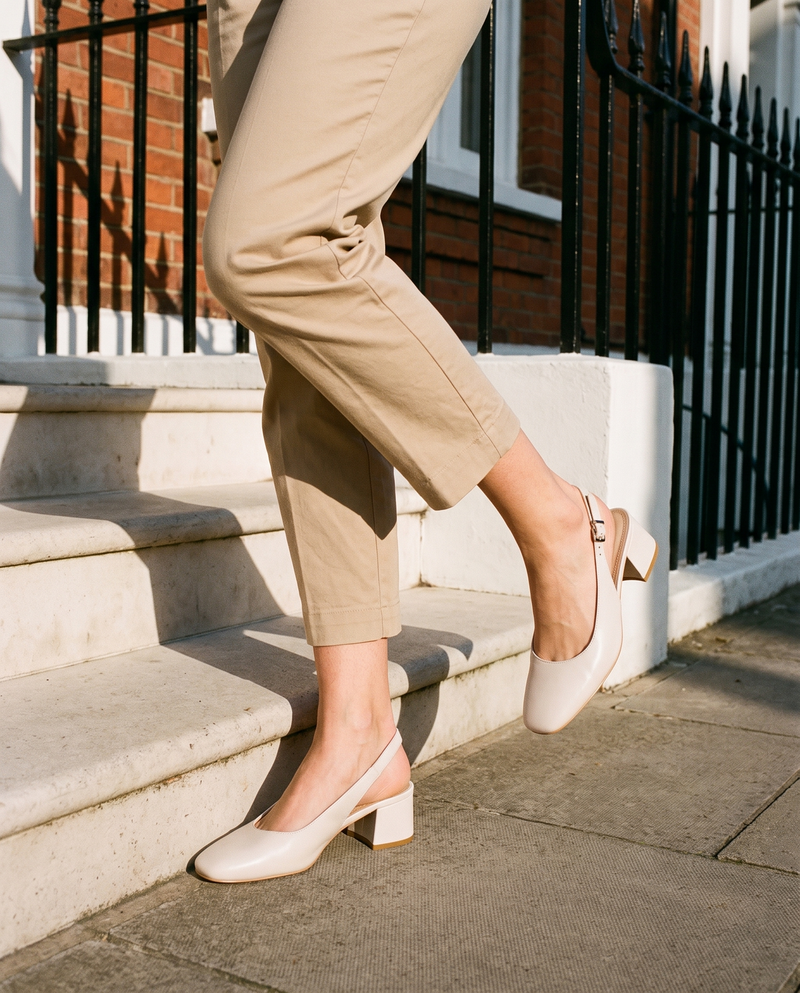 Slingback OLIVIA beige portée, gros plan, un pied posé sur la marche d'une maison londonienne