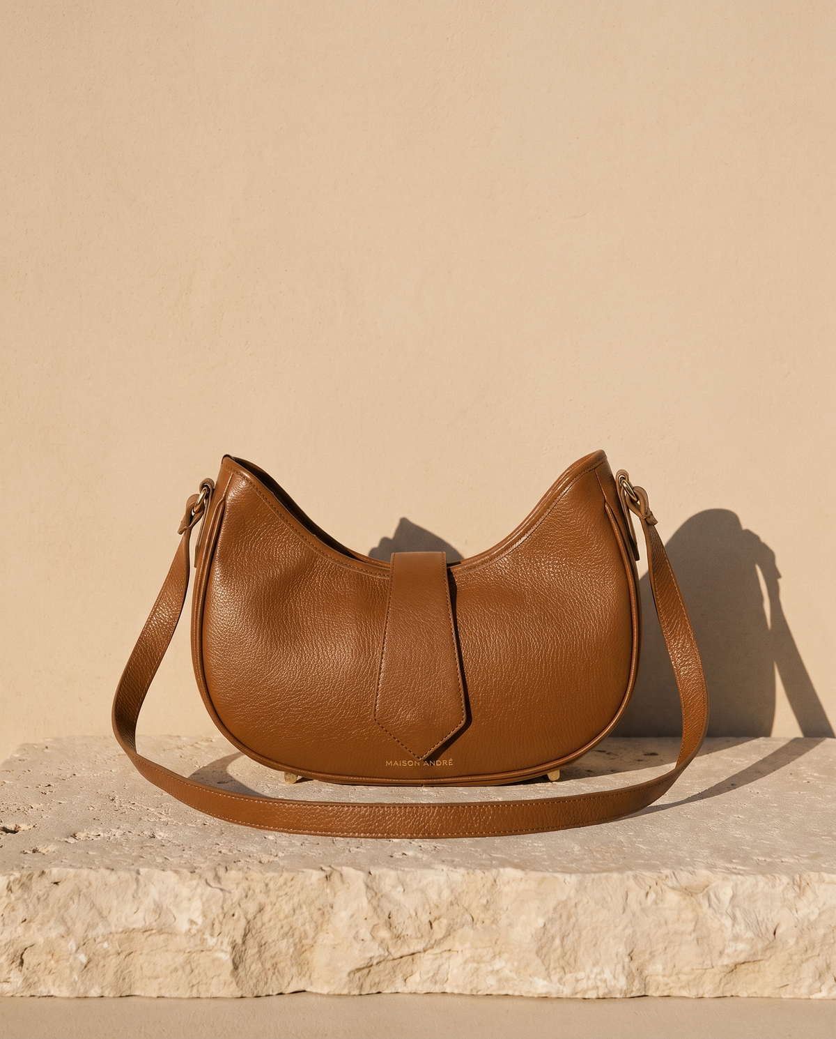 Sac PANTHEON cognac Maison André sur une marche en pierre